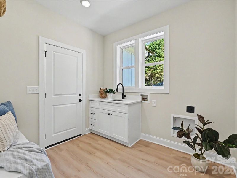 Functional and stylish laundry room features built-in cabinetry, utility sink, and dedicated space for everyday convenience.