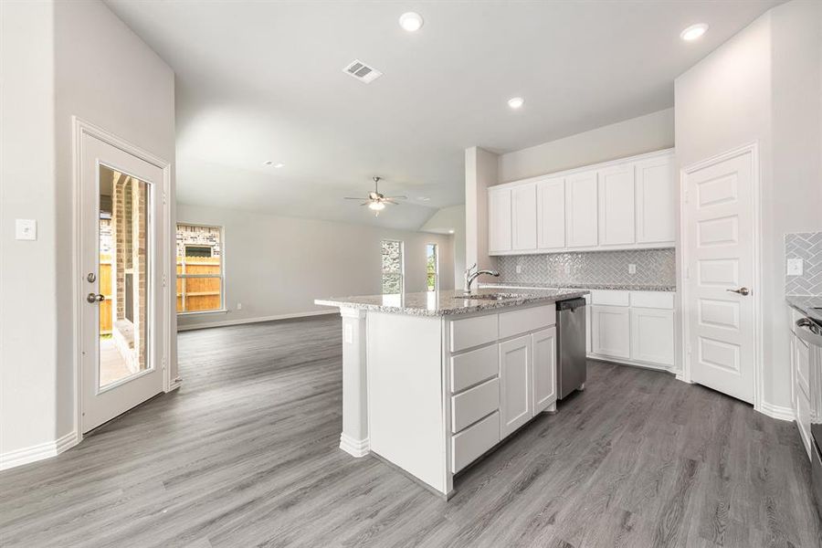 Kitchen featuring ceiling fan, light hardwood / wood-style flooring, white cabinets, and tasteful backsplash