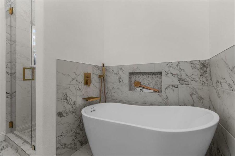 Bathroom featuring shower with separate bathtub and tile walls