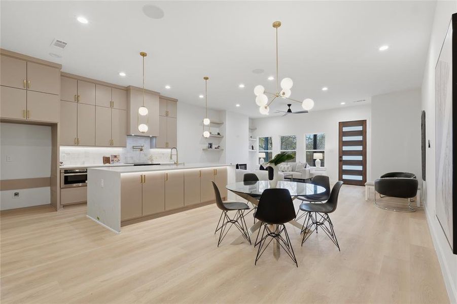 Dining space with light wood-type flooring and hanging lights Dining space with light wood-type flooring and hanging lights