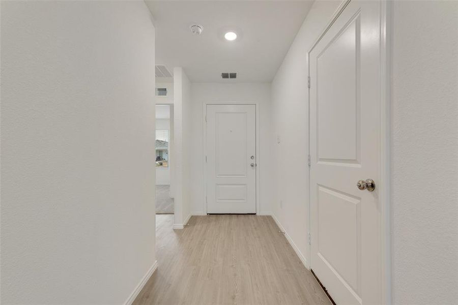 Hallway with light hardwood / wood-style flooring