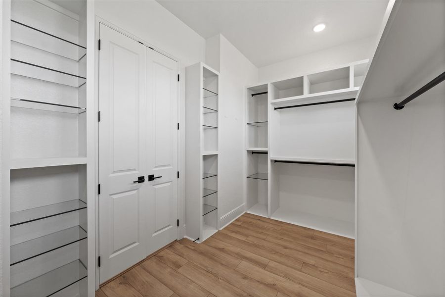 Spacious closet featuring light wood-style flooring
