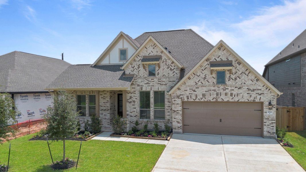 Front exterior of a new home in Coastal Point, League City, TX, highlighting curb appeal (Image 1).