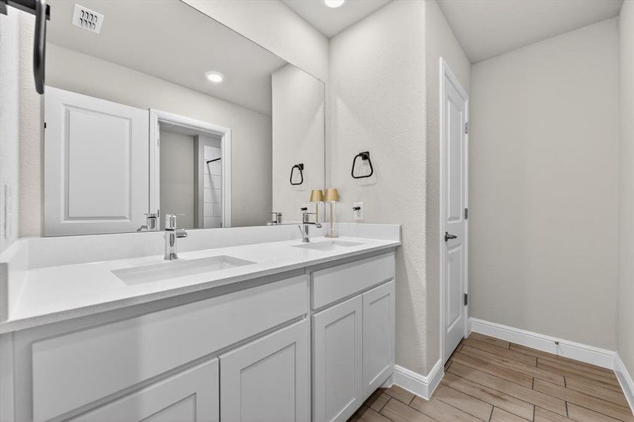 Dual vanity with integrated rectangular sinks, white countertops, chrome fixtures, and white shaker-style cabinetry