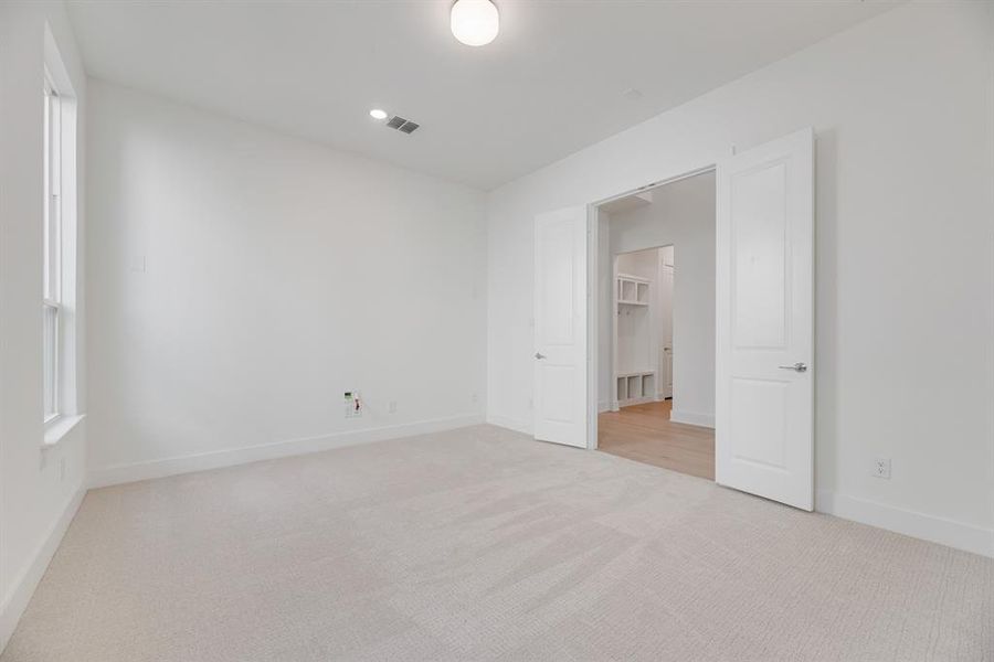 Unfurnished bedroom featuring light colored carpet and baseboards
