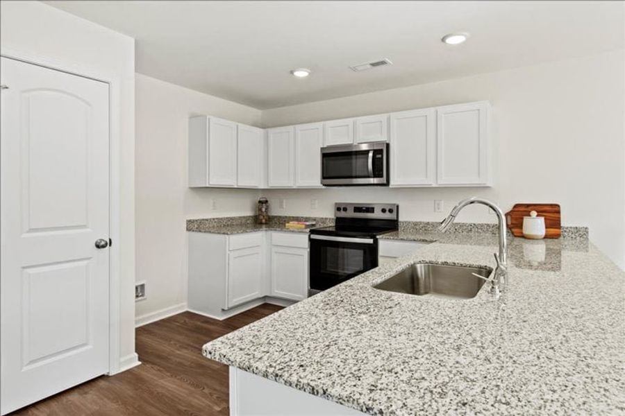 A kitchen with white cabinets.