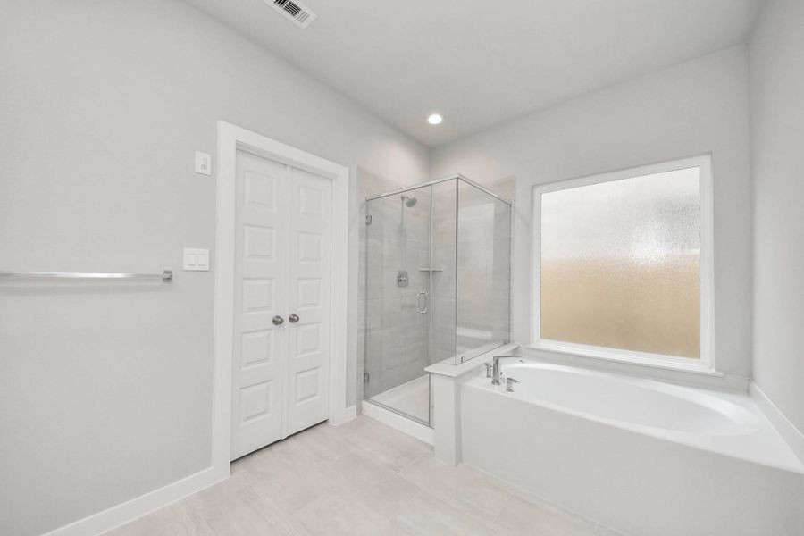 Indulge in a spa-like retreat within the confines of this primary bathroom. Delight in a spacious walk-in shower enveloped in stylish tile surround, unwind in a separate garden tub adorned with custom detailing. Sample photo of completed home with similar floor plan. Actual colors and selections may vary. Indulge in a spa-like retreat within the confines of this primary bathroom. Delight in a spacious walk-in shower enveloped in stylish tile surround, unwind in a separate garden tub adorned with custom detailing. Sample photo of completed home with similar floor plan. Actual colors and selections may vary.