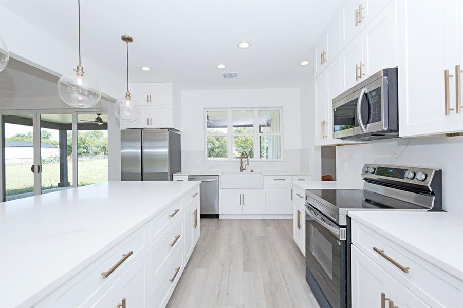 Kitchen with stainless steel appliances, healthy amount of natural light, recessed lighting, and light countertops