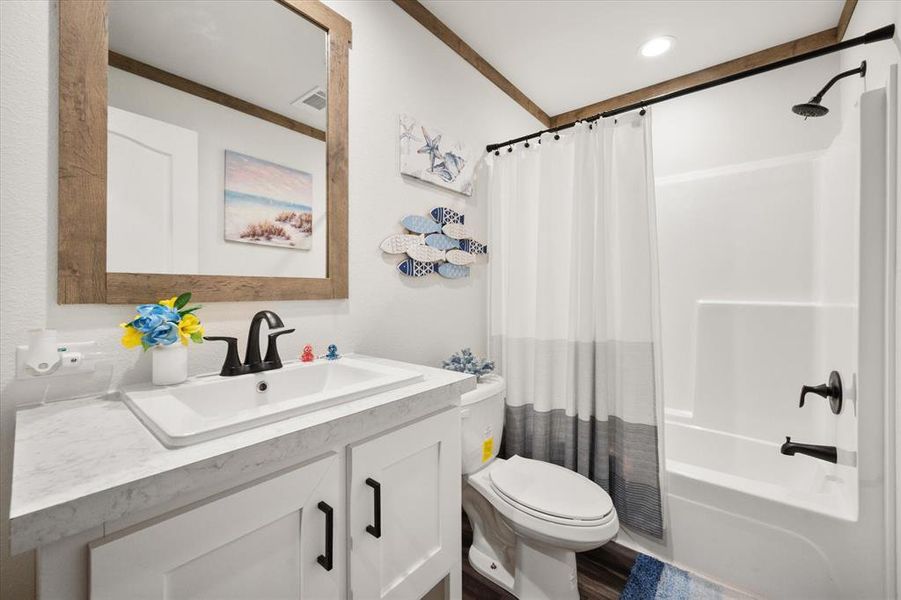 Bathroom featuring shower / bath combo, vanity, and ornamental molding Bathroom featuring shower / bath combo, vanity, and ornamental molding