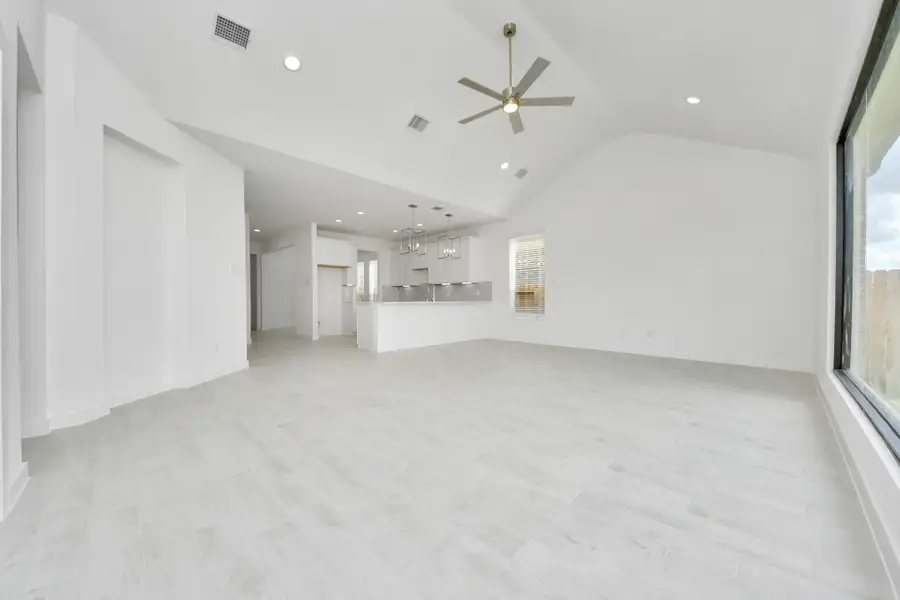 Gather the family and guests together in your lovely living room! Featuring soaring high ceilings, recessed lighting, ceiling fan, custom paint, gorgeous floors, and large windows that provide plenty of natural lighting throughout the day.