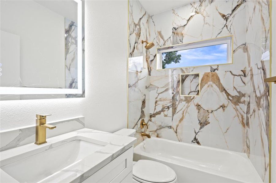 Full bathroom featuring vanity, toilet, and shower combination Full bathroom featuring vanity, toilet, and shower combination