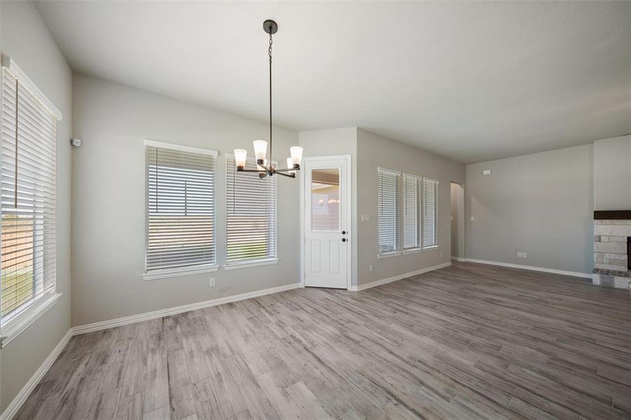 Unfurnished dining area with a chandelier and wood finished floors Unfurnished dining area with a chandelier and wood finished floors