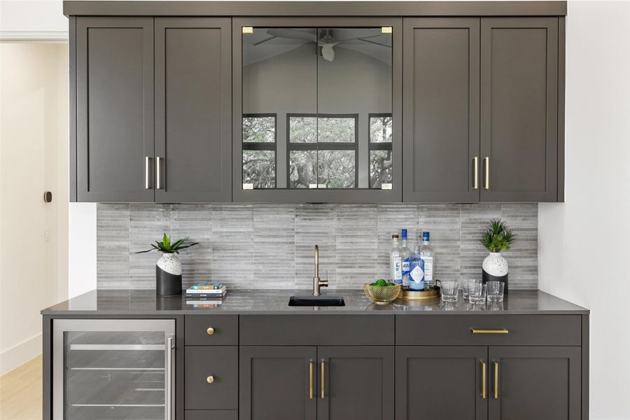 Bar featuring indoor wet bar, backsplash, a sink, and wine cooler Bar featuring indoor wet bar, backsplash, a sink, and wine cooler
