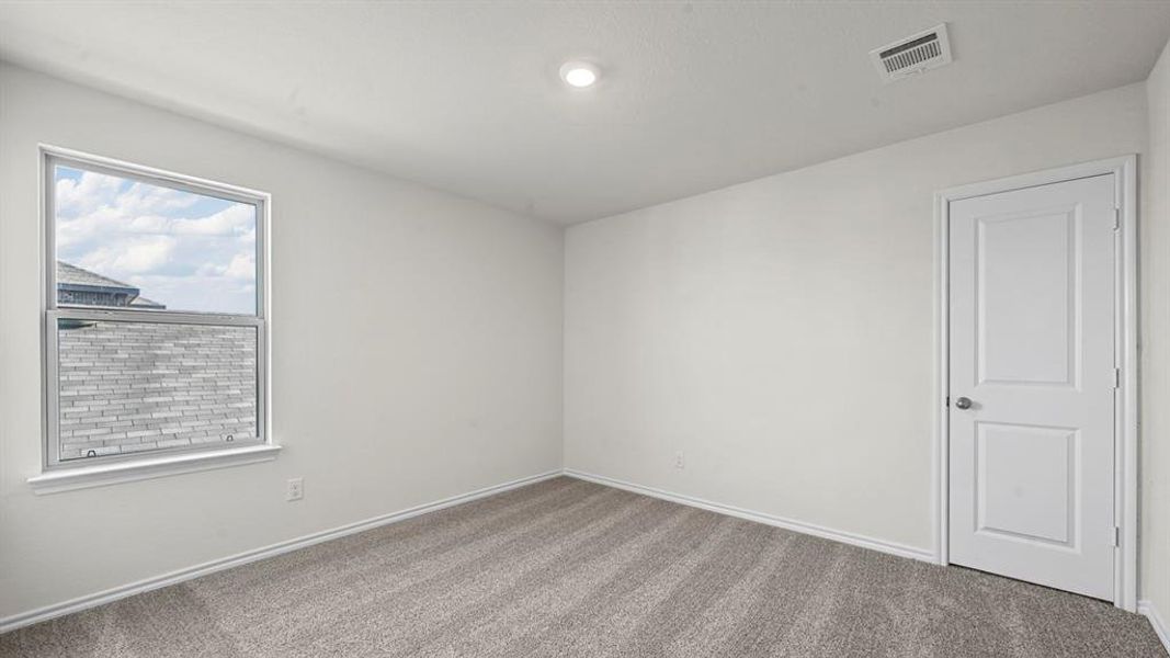 Carpeted room featuring a single window with a white frame, a recessed ceiling light, and a white paneled door