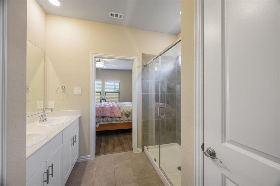 Bathroom featuring a double vanity with white cabinetry, dual undermount sinks, and chrome faucets Bathroom featuring a double vanity with white cabinetry, dual undermount sinks, and chrome faucets