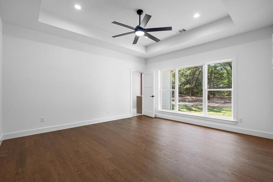 Spare room featuring a raised ceiling, dark wood-type flooring, recessed lighting, and a ceiling fan Spare room featuring a raised ceiling, dark wood-type flooring, recessed lighting, and a ceiling fan