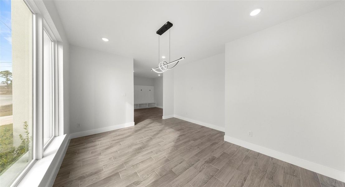 Unfurnished dining area with wood tiled floors, recessed lighting, and a chandelier