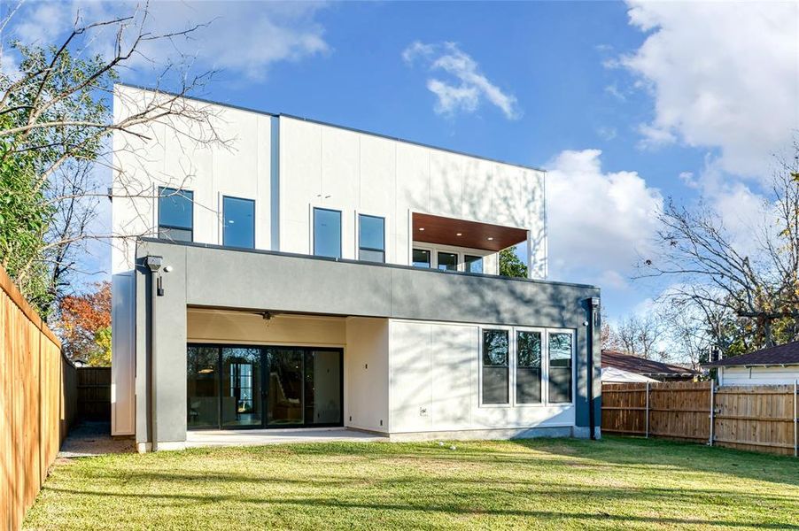 Rear view of property featuring a patio, ceiling fan, and a lawn