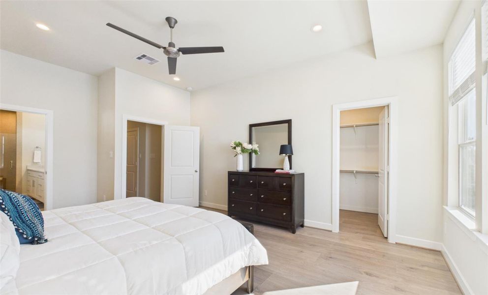 Enter into the large primary bedroom with high ceilings