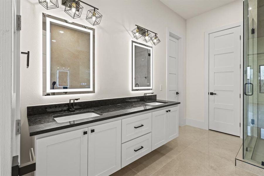 Bathroom featuring tile patterned flooring, vanity, and a shower with shower door