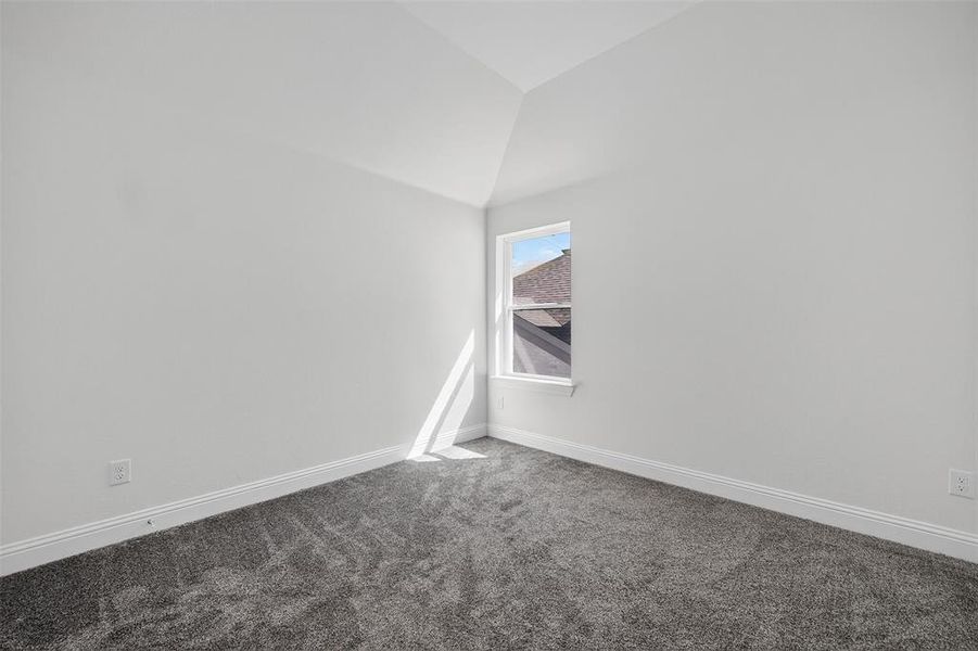Empty room featuring carpet and lofted ceiling Empty room featuring carpet and lofted ceiling