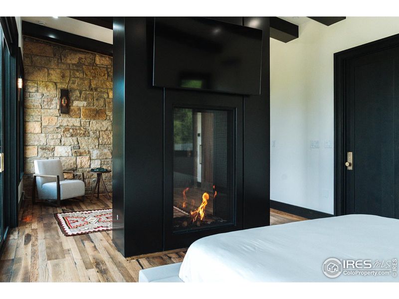 Primary Suite. Custom steel double sided fireplace looking towards private sitting area