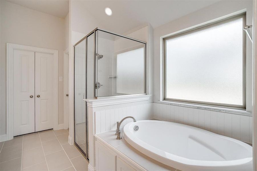 Bathroom featuring a wealth of natural light, separate shower and tub, and tile patterned floors