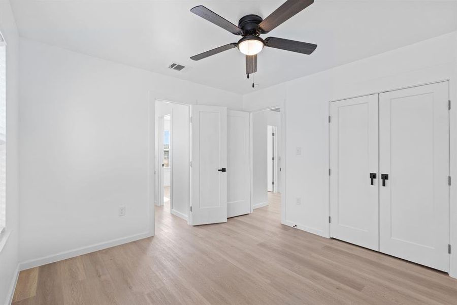 Unfurnished bedroom with a closet, light hardwood / wood-style floors, and ceiling fan