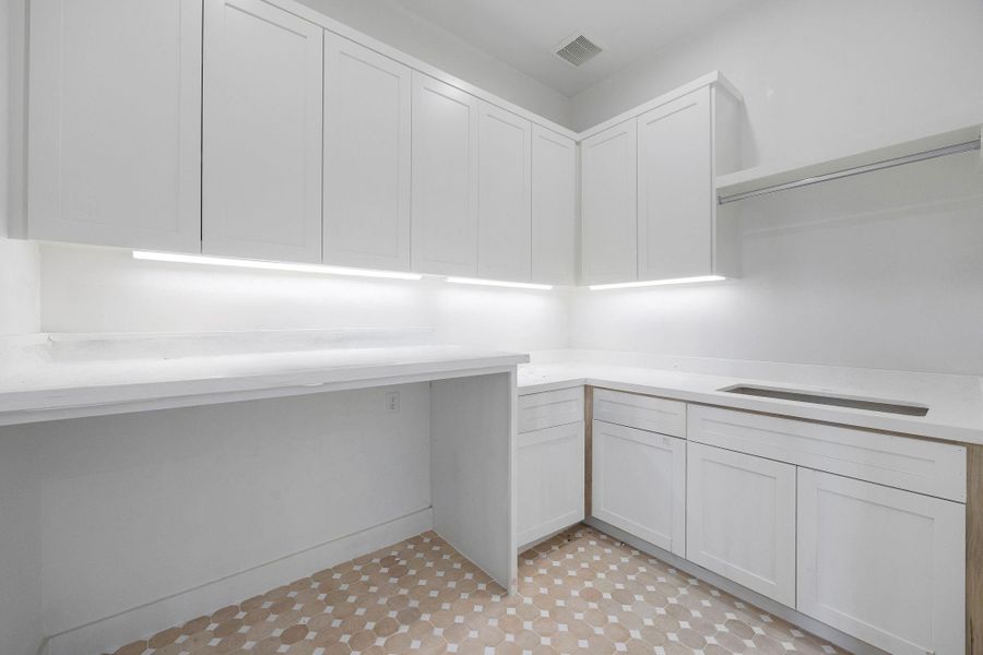 Upstairs, a spacious laundry room with a utility sink offers convenience and ample storage space. Upstairs, a spacious laundry room with a utility sink offers convenience and ample storage space.