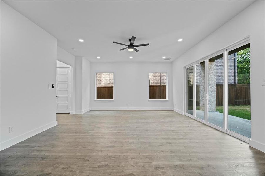 Empty room featuring plenty of natural light, ceiling fan, recessed lighting, and wood finished floors Empty room featuring plenty of natural light, ceiling fan, recessed lighting, and wood finished floors