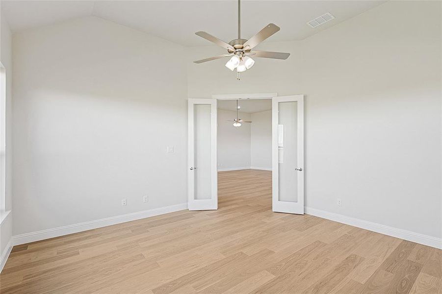 Spare room featuring french doors, ceiling fan, light hardwood / wood-style flooring, and lofted ceiling