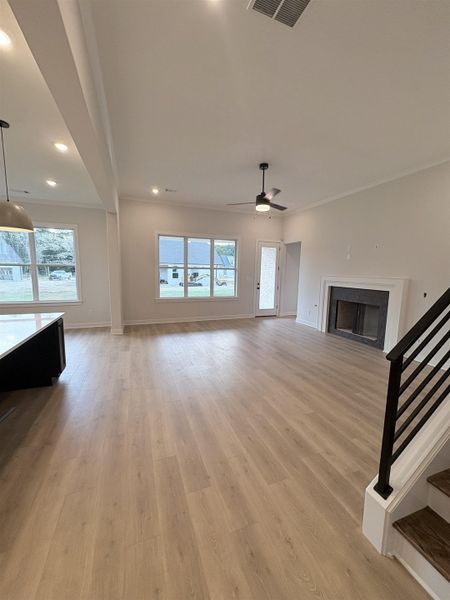 Open-concept living space featuring wood-finish flooring, recessed lighting, and multiple windows Open-concept living space featuring wood-finish flooring, recessed lighting, and multiple windows