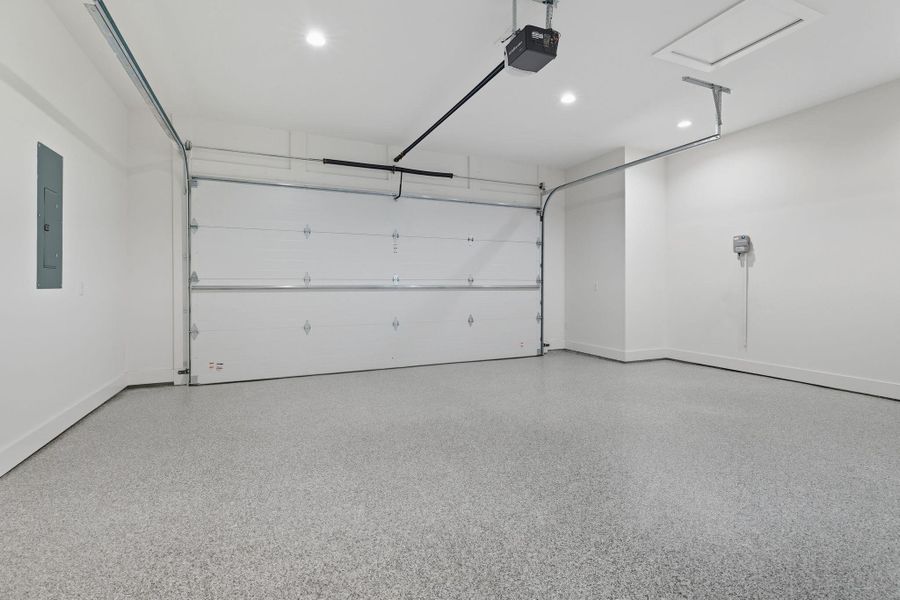 Garage featuring recessed lighting, a garage door opener, and electric panel Garage featuring recessed lighting, a garage door opener, and electric panel