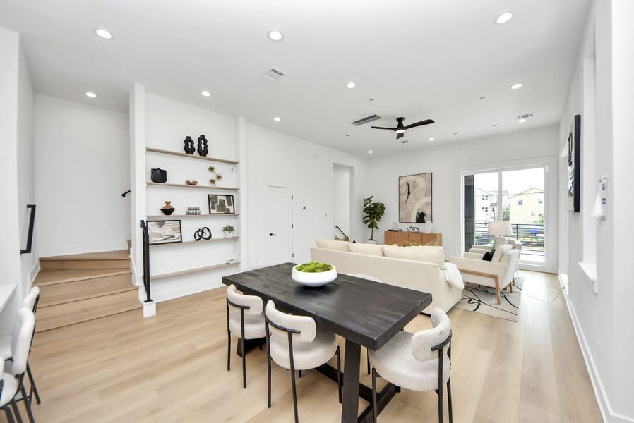 Spacious second-floor dining and living area with custom shelving and direct access to the balcony.