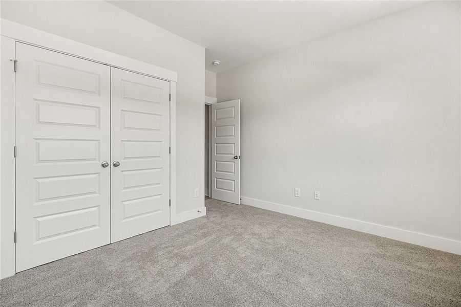 A spacious, neutral-toned room features soft carpe A spacious, neutral-toned room features soft carpe