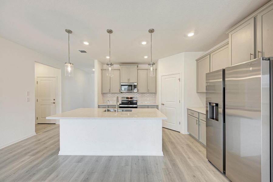 Culinary delights await in this bright kitchen with a spacious island, pendant lights, and ample storage.