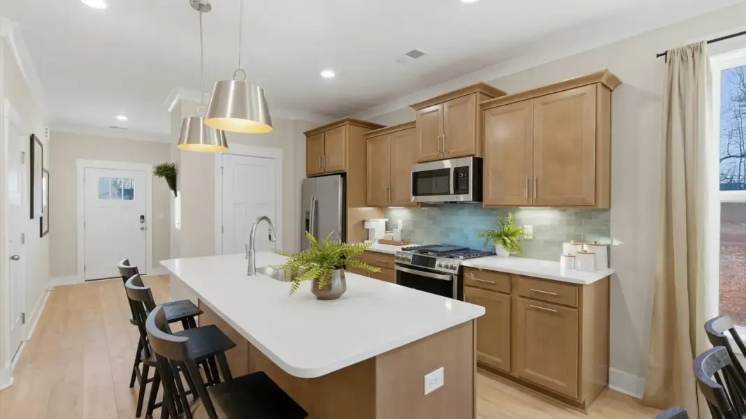 Vibrant and open kitchen centered around a 9-foot island with elegant pendant lighting above located in Greenville, SC