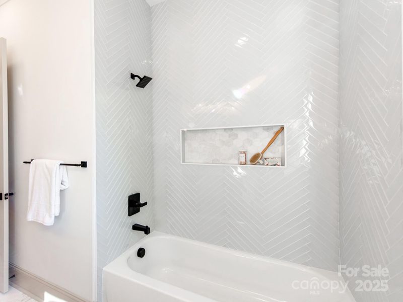 Individually Hand Laid Glass Tile Around the Tub with Marble Niche