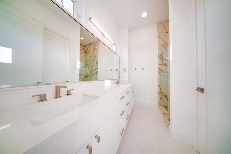 Bathroom with vanity, tiled shower, and tile patterned floors