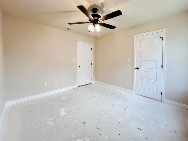 Unfurnished bedroom featuring ceiling fan and concrete floors Unfurnished bedroom featuring ceiling fan and concrete floors