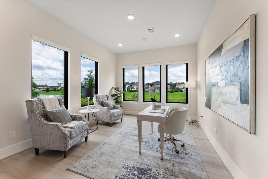 A private front room offers an ideal setting for a home office, formal dining, reading lounge, or quiet retreat. Large windows bring in natural light and lake views while keeping the space connected to the home’s polished design.