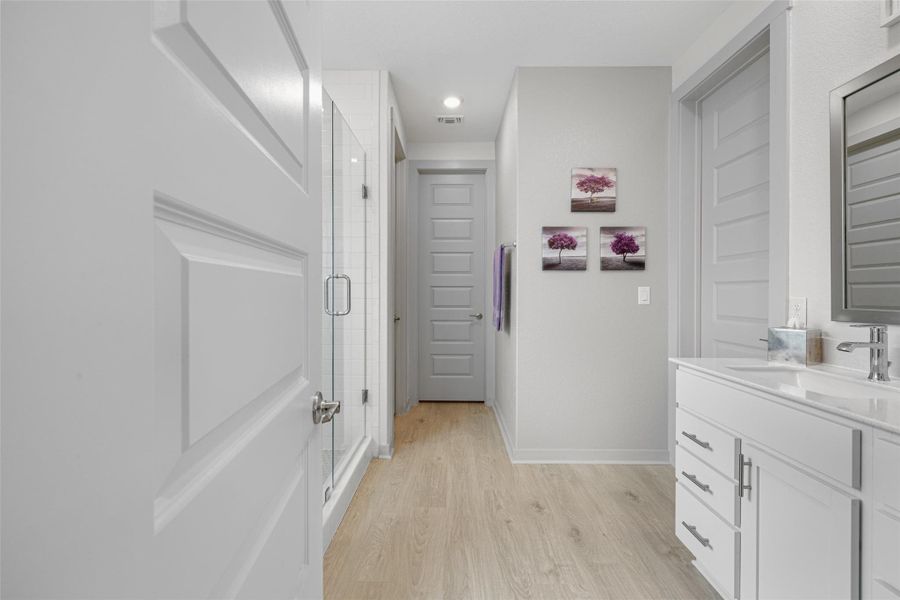 Bathroom with vanity, a stall shower, and light wood-style flooring Bathroom with vanity, a stall shower, and light wood-style flooring