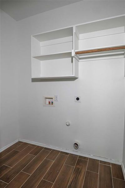 Laundry area with hookup for a washing machine, hookup for a gas dryer, dark wood-type flooring, and hookup for an electric dryer