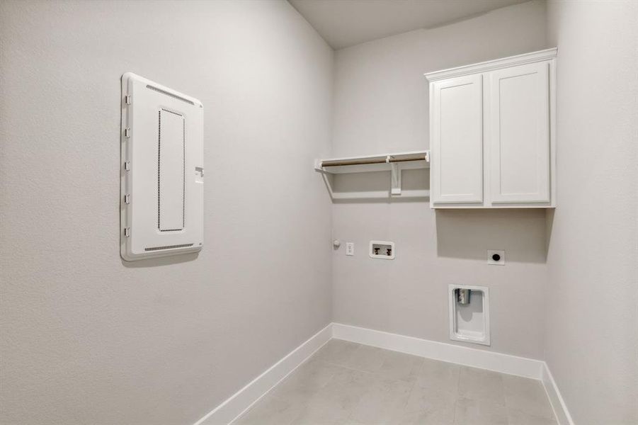 Clothes washing area with hookup for an electric dryer, light tile patterned floors, cabinets, washer hookup, and hookup for a gas dryer