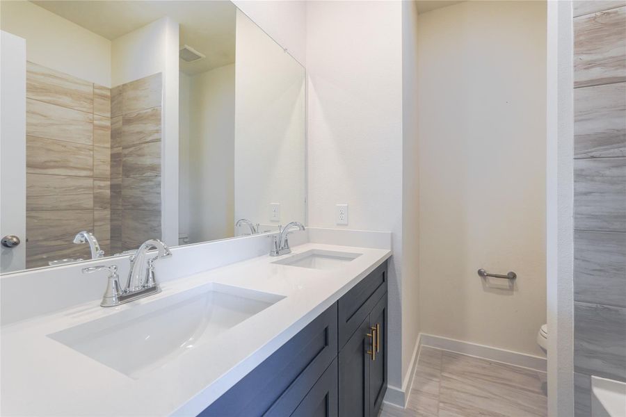 This spacious bedroom features plush carpeting, neutral walls, and ample natural light from two large windows. It includes a ceiling fan for comfort and a set of double doors leading to an en-suite bathroom with modern fixtures. This spacious bedroom features plush carpeting, neutral walls, and ample natural light from two large windows. It includes a ceiling fan for comfort and a set of double doors leading to an en-suite bathroom with modern fixtures.