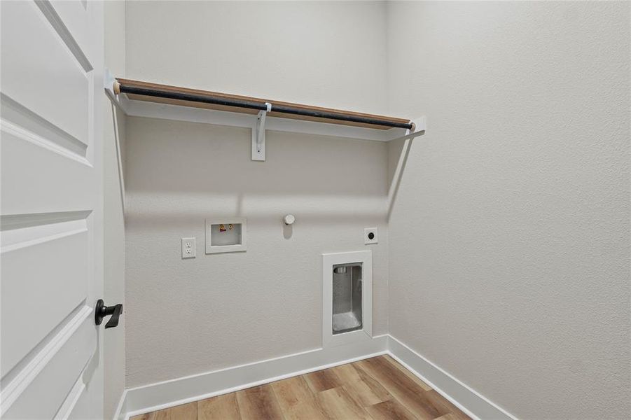 Laundry room with hookup for a gas dryer, light wood-style floors, washer hookup, and hookup for an electric dryer