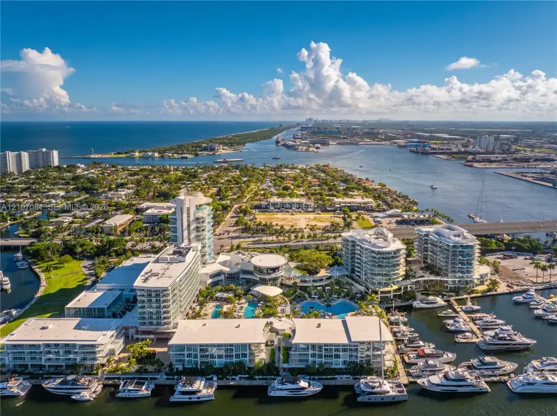 Waterfront complex featuring high-rise buildings, an integrated marina, multiple swimming pools, and extensive coastal landscape Waterfront complex featuring high-rise buildings, an integrated marina, multiple swimming pools, and extensive coastal landscape