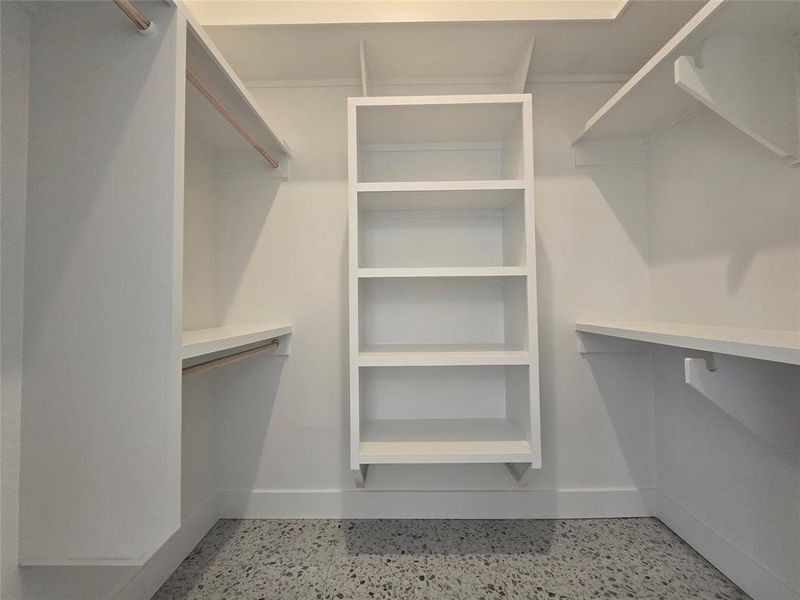 Large walk in primary walk in closet with lots of storage organization options.