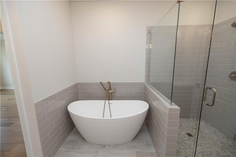 Bathroom with independent shower and bath and tile walls