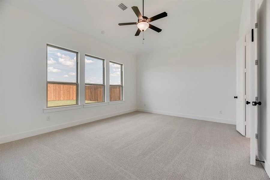 Empty room with light carpet and ceiling fan Empty room with light carpet and ceiling fan